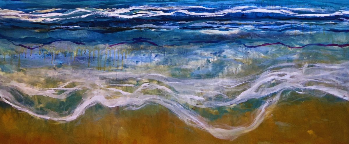 White surf running up ochre sand